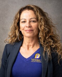 woman with long curly hair and a WNMU Scrubs shirt