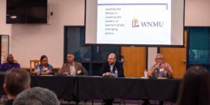 Five people sitting at a panelist table.