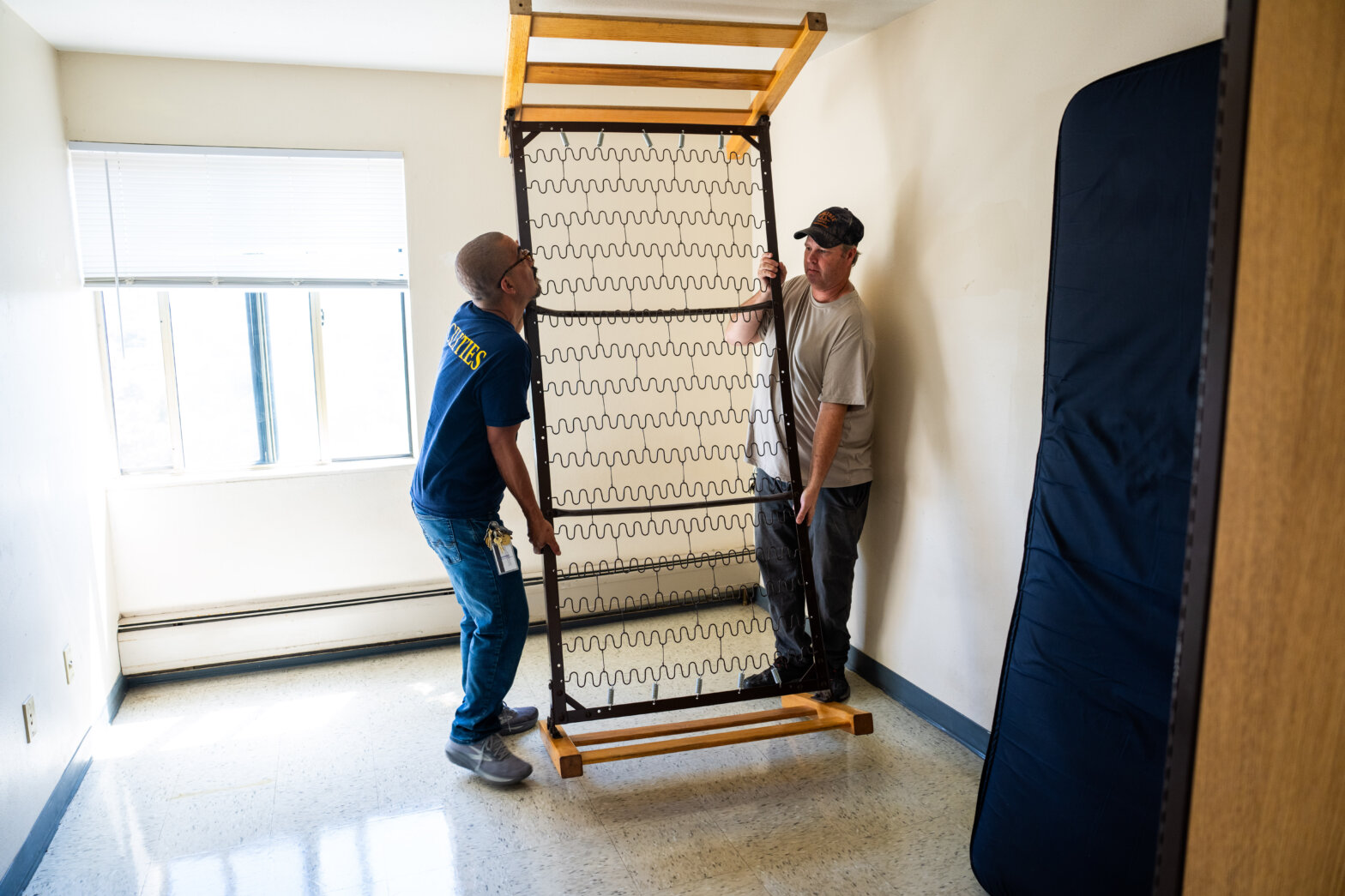 Two men putting a frame bed back together