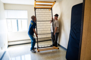 Two men putting a frame bed back together