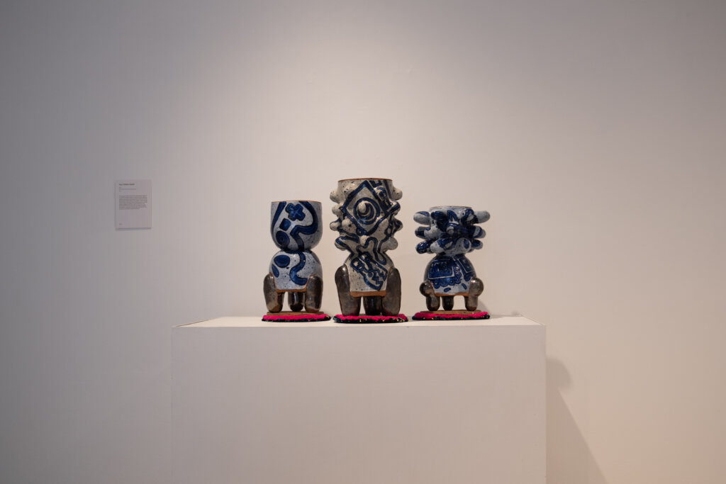 Three sculptures of pots marrying indigenous styles with modern styles.